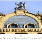 "Grand Hotel Europa" und "Hotel" auf gelber Fassade, mit klassischen Statuen und dekorativen Elementen.
