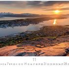 Mitternachtssonne in Tromsø. Monat: November. Panorama mit Bergen, Stadt, Wasser und Sonnenuntergang.