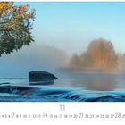 Text: "Morgenstimmung am Fluss". Ein nebeliger Fluss umgeben von Herbstbäumen, sanftes Licht, ruhige Wasseroberfläche.