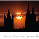 "Sunset" und "CASARES EDITION" sind zu lesen. Silhouette einer Stadt bei Sonnenuntergang, Vögel fliegen vor der Sonne.