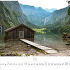 „Obersee“ und „11“. Eine Holzhütte steht auf einem ruhigen See, umgeben von majestätischen Bergen und dichter Vegetation.