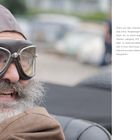 Andreas Bitterli, Oldtimer-Enthusiast. Er trägt eine Pilotenkappe und Brille, sitzt in einem offenen Auto mit grauem Bart.