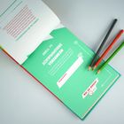 Text: "DUELL #1 SCHWIMMTIERE VERSENKEN." Türkises Buch, aufgeschlagen. Drei bunte Bleistifte daneben.