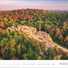 November. Kalendertage darunter. Herbstliche Waldlandschaft mit Felsen in sanftem Licht.