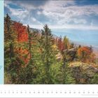 "Auf dem Goldsteig Grenzen überschreiten. Deutschland/Tschechien. Streckendetails: 66 km, 4 Etappen, Start/Ziel: Zwieseler Waldhaus." 

Ein herbstlicher Wald mit buntem Laub, Nadelbäumen und Felsen vor einem weiten Tal und bewölktem Himmel.