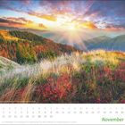 Kalenderblatt für November mit Wochentagen und Daten. Herbstlandschaft mit buntem Laub, Wiese und Sonnenstrahlen über Hügeln.
