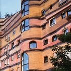 11 2027. Ein farbenfrohes Gebäude mit goldener Zwiebelkuppel und unregelmäßiger Fassade, umgeben von Bäumen.