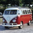 Kennzeichen: D-ZY 6H. Ein klassischer, rot-weißer VW-Bus mit Dachgepäckträger und Rundscheinwerfern, steht im Freien.