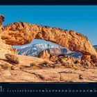 Unten links "11 2021". Ein natürlicher Steinbogen vor schneebedeckten Bergen unter klarem blauem Himmel. Kalenderdarstellung.