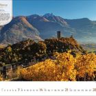 Walliser Weinweg: Petite Arvine 11/2024. Malerische Herbstlandschaft mit Weinreben, Hügeln und einer Burg im Hintergrund.