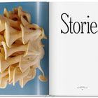 Text: "Stories". Links organische, trompetenartige Formen vor blauem Hintergrund.