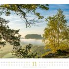 Kalenderseite November. Blick auf landschaftliche Szene mit Bäumen, Bergen und Nebel.