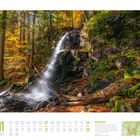 November 2027 Kalender mit einem Herbstwasserfall im Wald, umgeben von buntem Laub und dichten Bäumen.