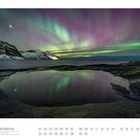 11 HURTIGRUTEN, Polarlichter über der Insel Senja, Troms/Norwegen. Farbige Nordlichter über verschneiten Bergen und ruhigem Wasser.