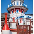 "LEUCHTTURM" ist auf einem Schild an einem rot-weißen Gebäude. Darunter steht: 10. März und die Wochentage.