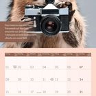 Zitat: "Das Leben ist wie eine Kamera...Mache ein neues Bild." Ein Waschbär hält eine Kamera und darunter ist ein Monatskalender.