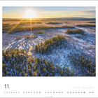 "Nationalpark Vodloza, Nordkarelien (Ru), 11, Kalenderseite. Ein Sonnenaufgang über einem verschneiten, bewaldeten Gebiet."