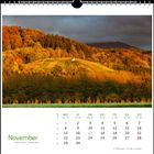 November-Kalender. Montags grün, Samstags schwarz, Sonntags rot. Herbstlandschaft mit farbenfrohen Bäumen und Hügel.