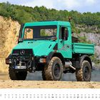 Unimog 418 Baujahr 1996. Kalender von November. Türkisfarbener Lastwagen in einer Steinbruchlandschaft.