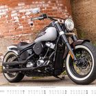 „November“ und ein Kalender unten. Ein Motorrad parkt vor einer alten Ziegelmauer.