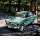 Text: "Alfa Romeo Giulia TI" und "NOVEMBER". Ein grünes Oldtimer-Auto parkt vor einem geöffneten, kunstvollen Tor.
