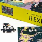 Gelber Karton mit der Aufschrift "Die Welt der Hexen", Teile eines Puzzles mit illustrativen Hexenmotiven.