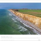 November 2027, Am Meer. Steilküste, grüne Felder, bewölkter Himmel, Meer mit Wellen, Küstenlinie, Kalenderblatt.