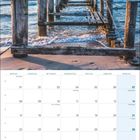 Novemberkalender 2027 mit Feiertagen. Oben ein hölzerner Steg, der in ein ruhiges Meer führt, bei Sonnenuntergang.