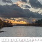 November 2027 Kalender. Herbstliche Landschaft mit See, Bäumen und dramatischem Himmel.