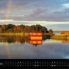 Kalenderblatt "Schweden 11". Ein See mit einem roten Häuschen, Bäumen und einem Regenbogen im Hintergrund.