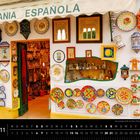 Text: "ARTESANIA ESPAÑOLA". Bunte Keramikteller und -dekorationen schmücken eine Marktstraße in Andalusien.