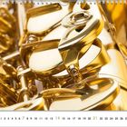 Kalenderseite mit Zahlen 1 bis 30. Nahaufnahme von glänzenden, goldfarbenen Saxophontasten.