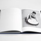 Text oben links: "Untitled (Menina)". Text unten: "2015". Ein Kind betrachtet einen großen Baumstammquerschnitt.