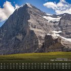 Text unten: "Eiger Nordwand - 3.967 m (Schweiz) 12". Kalender über grüne Wiese, majestätischer Berg, blauer Himmel mit Wolken.
