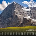 "Eiger Nordwand - 3.967 m (Schweiz)" gefolgt von Kalendertagen. Majestätischer Berg über grüner Wiese mit einigen Kühen.