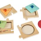 „Montessori by Eichhorn“ auf einem Holzpuzzle mit bunten, geometrischen Formen zum Einsetzen.