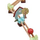 Eine Holz-Murmelbahn mit bunten Details wie einem Regenbogen, Häuschen und Baum. Eine rote Murmel ist darauf zu sehen.