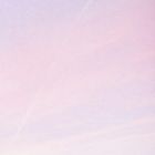 Ein zart rosa- und lilafarbener Himmel mit sanften Farbverläufen und leichten Wolkenspuren.