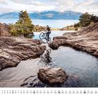 Kalenderblatt Dezember; eine Person springt mit einem Fahrrad über eine Felsformation vor einer malerischen Bergkulisse.