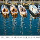 12, 1 bis 31 mit Tagen darunter. Boote an einem Holzsteg spiegeln sich im Wasser.