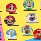 Verschiedene gehäkelte Figuren auf Sockeln mit Beschreibungen wie "Schwarzhaarige Schönheit" und "Moderierender Frosch".