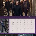 Kalenderseite für Dezember mit Fotos aus einem Film. Viele Personen gehen durch Trümmer. Feiertage sind markiert.