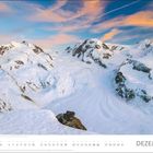 DEZEMBER unten rechts; Schneebedeckte Berge mit rosa Wolken am Himmel. Kalenderdaten darunter.