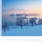 Große Adventsrunde um den Chiemsee. Deutschland Bayern Chiemgau. Verschneite Landschaft mit Insel, Bäumen und einem Schiff.