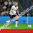 "Vorjahresabbildung" in großen, schräg gedruckten Buchstaben. Frau im Fußballtrikot läuft auf einem Spielfeld.