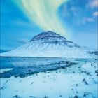 Kalender mit Dezember-Daten. Winterlandschaft mit schneebedecktem Berg und leuchtendem Polarlicht am Himmel.