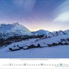 Dezember 2023. Kalender mit schneebedeckter Berglandschaft und kleinen Hütten unter einem sternenklaren Himmel.