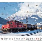 Der Text unter dem Bild gibt Lokomotivnummer an. Rote Lok auf verschneiten Schienen vor schneebedeckten Bergen und blauem Himmel.