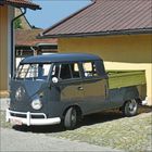 Kennzeichen: FB-C706. Grauer, alter Lieferwagen mit Ladefläche, steht neben einem gelben Gebäude auf Kopfsteinpflaster.