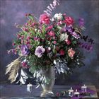 Ein bunter Blumenstrauß in einer Vase, mit Rosen, Anemonen und Eukalyptus, auf einem Tisch mit Kerzen dekoriert.